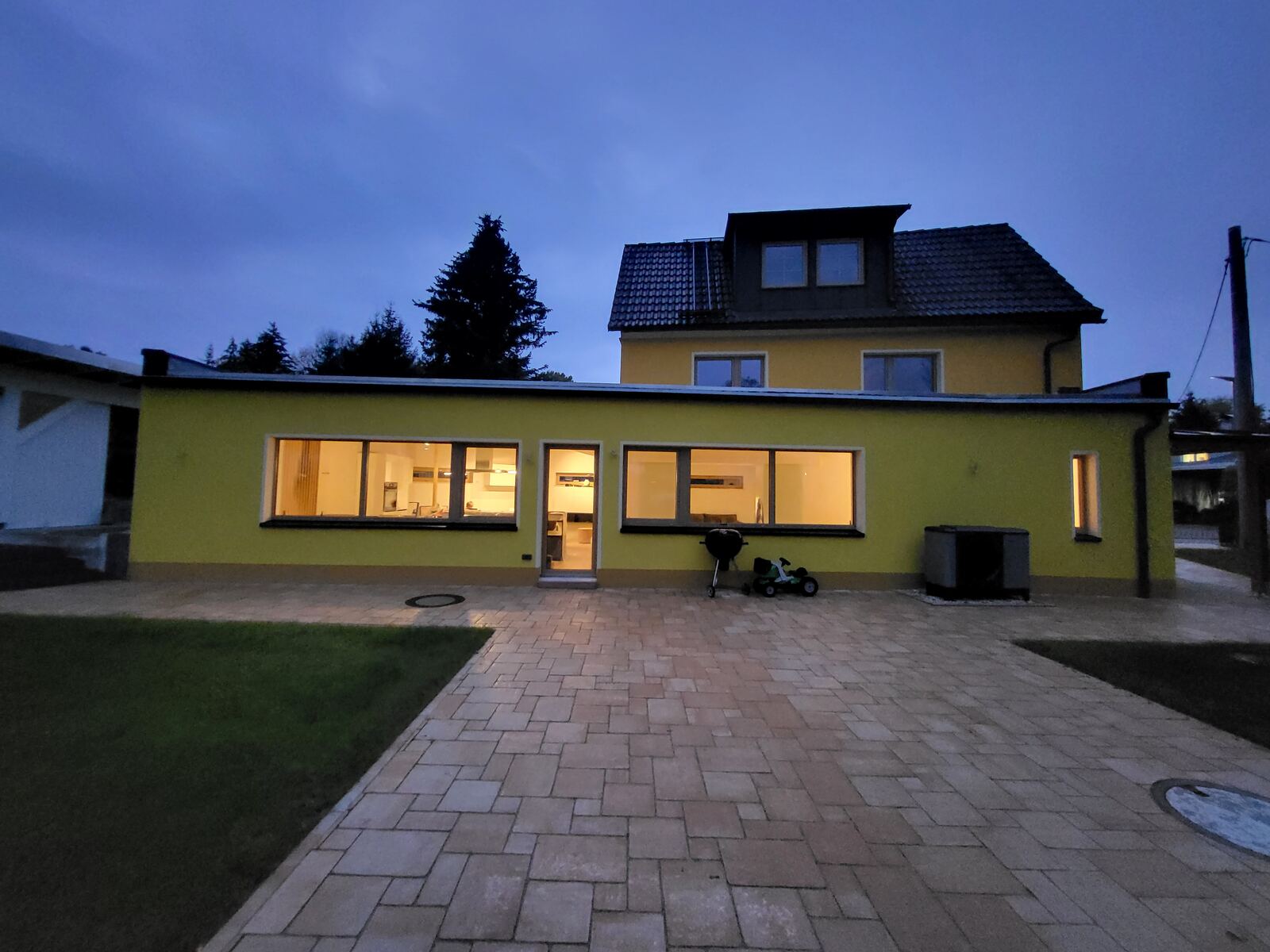 Das Haus in der Abenddämmerung mit erleuchteten Fenstern