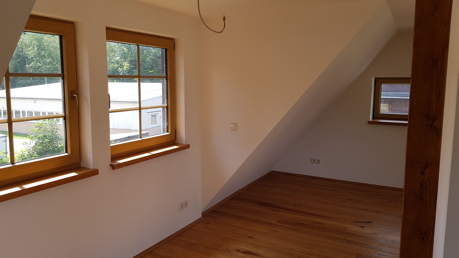 Raum mit Dachgaube und Holzfenstern
